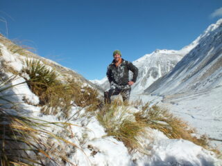 A man covered in snow in the mounatains.
